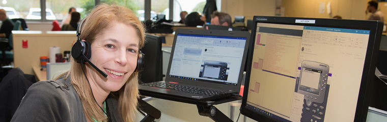 Person with a headset on sat by a computer